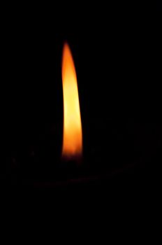 Candle flame in a darkened room. The flame providing the only light.