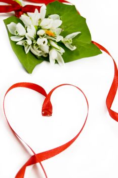 bouquet of snowdrops with twisted red ribbon in heart shape
