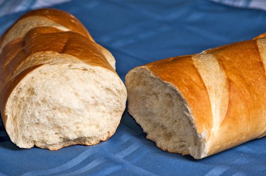 A delicious loaf of French bread broken open ready to butter and eat.