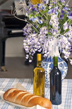 Two bottles of wine with a fresh load of French bread.