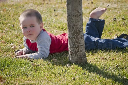 Little boy resting from busy time playing in the back yard.