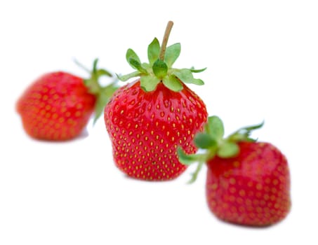 three strawberries, shallow depth of view, isolated on white