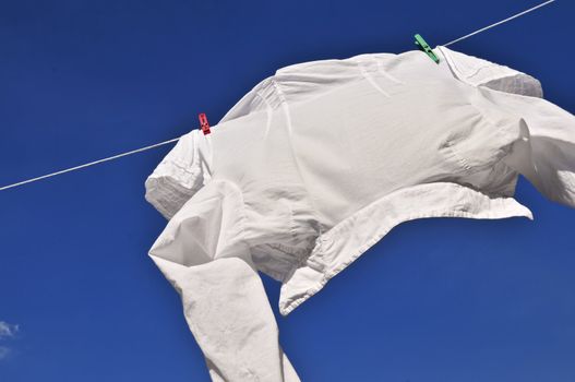 White shirt hanging to dry on clothes line