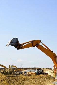 Yellow bulldozer machines digging and moving earth at construction site