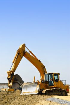 Yellow bulldozer machines digging and moving earth at construction site