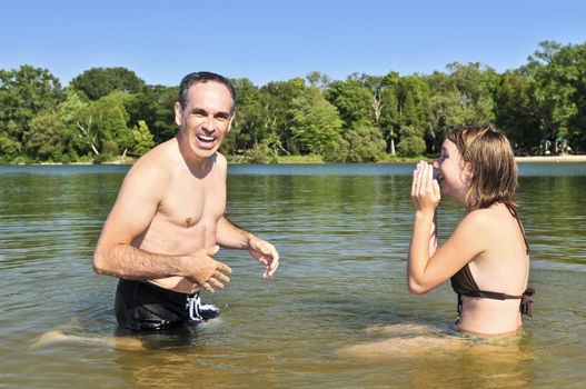Father and daughter splashing in a lake