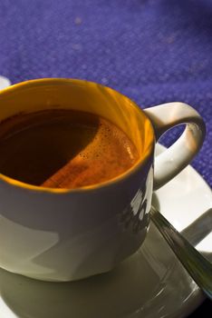 Double espresso in a white cup during sunset.