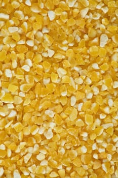 Yellow crushed maize cereals background close up