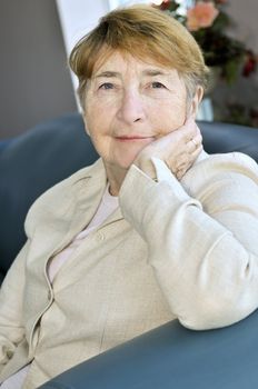 Elderly woman sitting in white linen jacket