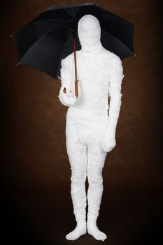 Mummy under umbrella on black background