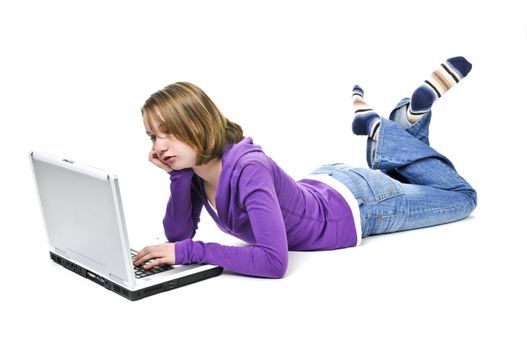 Bored young girl lying down with laptop computer