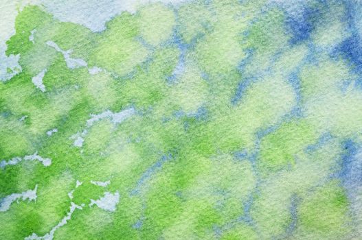 Blue colors slipping in with the green watercolors on textured paper