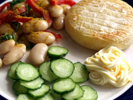 Vegetarian main dish including cheese, mayonnaise, curry beans, peppers and cucumbers