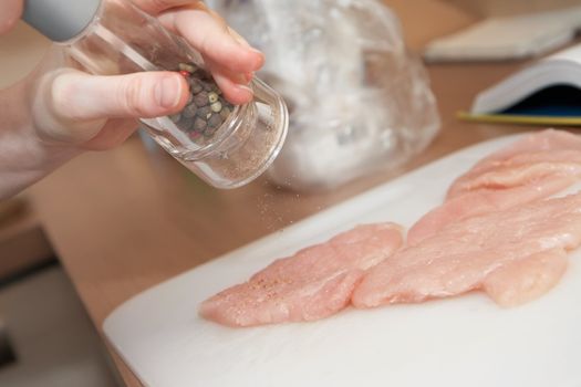 peppering meat using grinder, shallow DOF, close-up