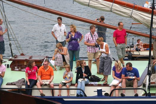 Mensen eten en drinken op een boot in de botenoptocht tijdens Sail 2101 in Amsterdam