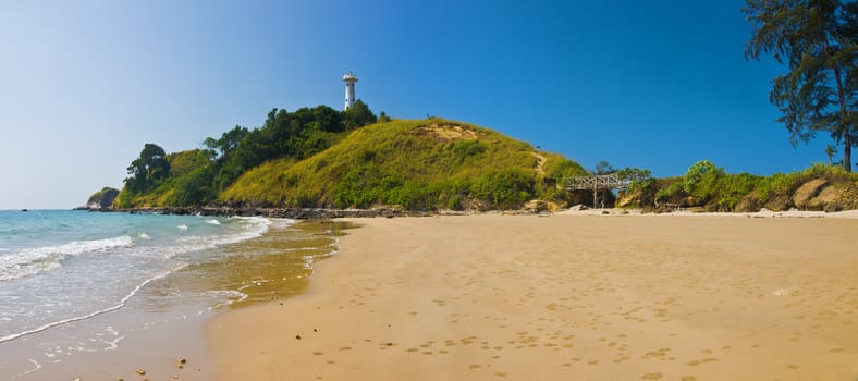 Wide tropical beach with lighthouse. Panoramic shot