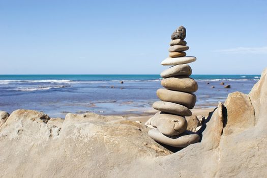 A stack of balanced stones with the beach in the background.