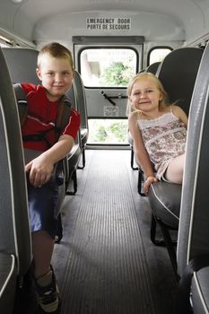 Photo of two happy children sitting in a school bus.