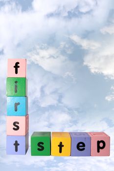 toy letters that spell first step against a cloudy background with clipping path