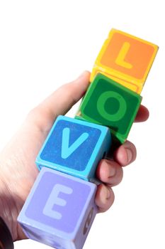toy letters that spell love held in hand with white background with clipping path