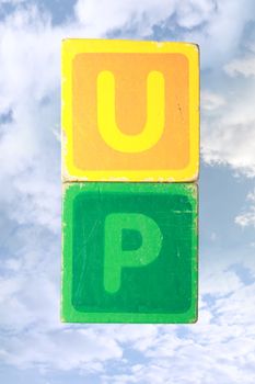 toy letters that spell up against a cloudy background with clipping path