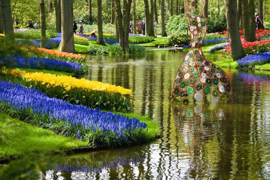 Pond in park in spring with colorful flowers