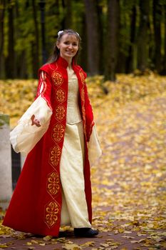 lady in medieval red dress in the autumn forest
