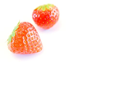 high key image of two strawberries with a shallow dof on a white background