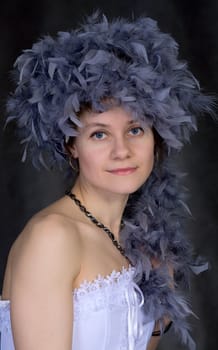 Portrait of the beautiful girl with a boa on a head