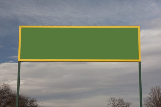 bright green with yellow framing, rectangular blank sigmn or billboard against cloudy sky and trees