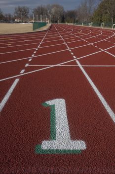 white lane number one at a starting line red running tracks