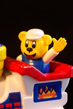 Childrens toy, a yellow bear driving a train and waving