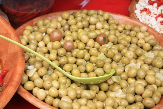 A bowl with green olives, marinated in garlic oil