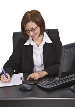 Smiling businesswoman taking notes at her desk. 