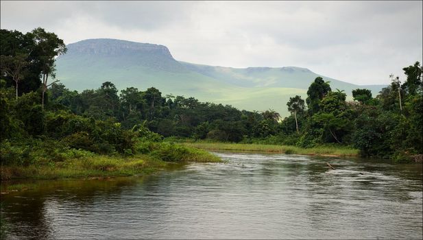 Small river in jungle. Under the cloudy sky through hills and mountains the small river proceeds on jungle.