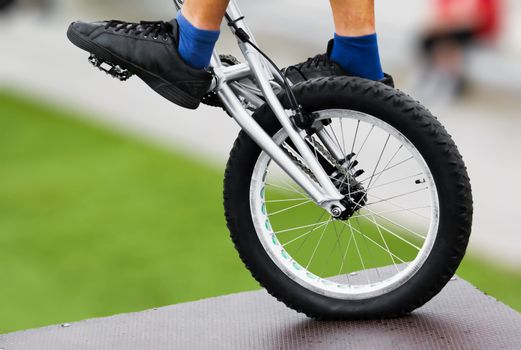 Closeup photograph of a bike trick, balancing on one wheel.