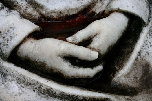 Stone hands in prayer
