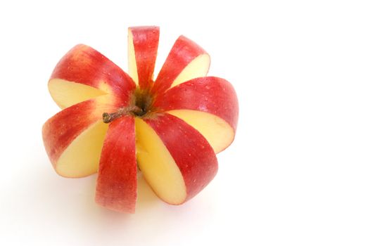 An apple is sliced to make a flower shape.
