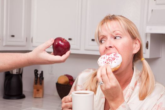 Couple in Kitchen Eating Donut and Coffee or Healthy Fruit.