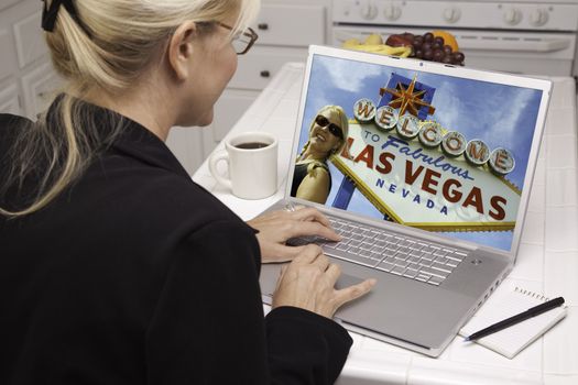 Woman In Kitchen Using Laptop to Research A Las Vegas Trip. Screen can be easily used for your own message or picture. Picture on screen is my copyright as well.