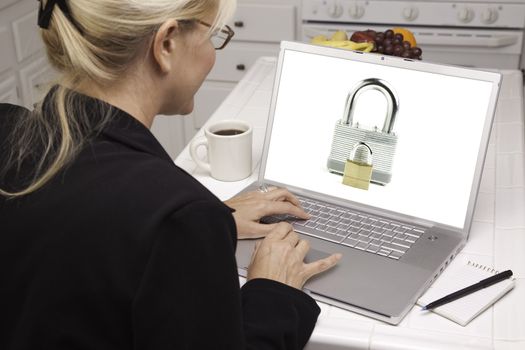 Woman In Kitchen Using Laptop with High Security Level. Screen can be easily used for your own message or picture. Picture on screen is my copyright as well.