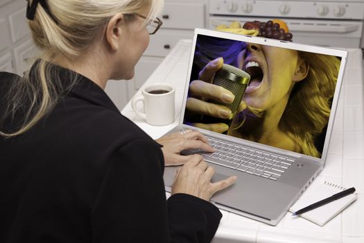 Woman In Kitchen Using Laptop for Music and Entertainment. Screen can be easily used for your own message or picture. Picture on screen is my copyright as well.