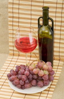 Still life with grapes and wine on mat