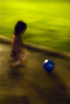 The girl and a ball. The little girl plays park a ball late at night.