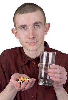 Boy with tablets and glass of water on his hand