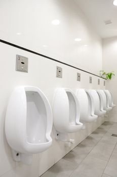 A mens public bathroom with urninals on the wall