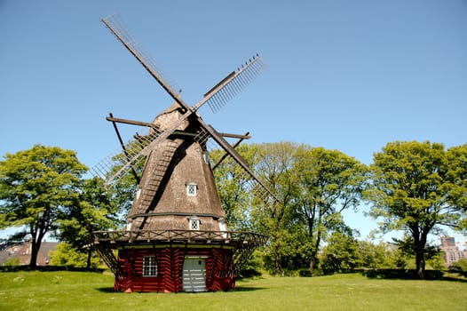 A old windmill in green nature and a clear blue sky