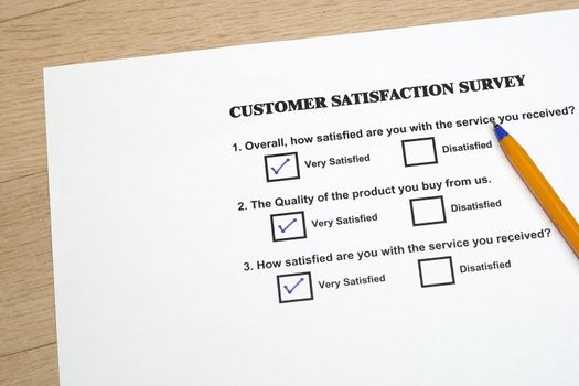 Product satisfaction survey concept with pen in a wooden tile background