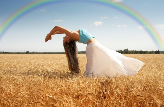picture of stretching woman in the meadow with rainbow