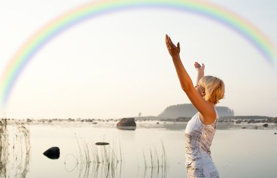 picture of pretty blond raising hands to the rainbow